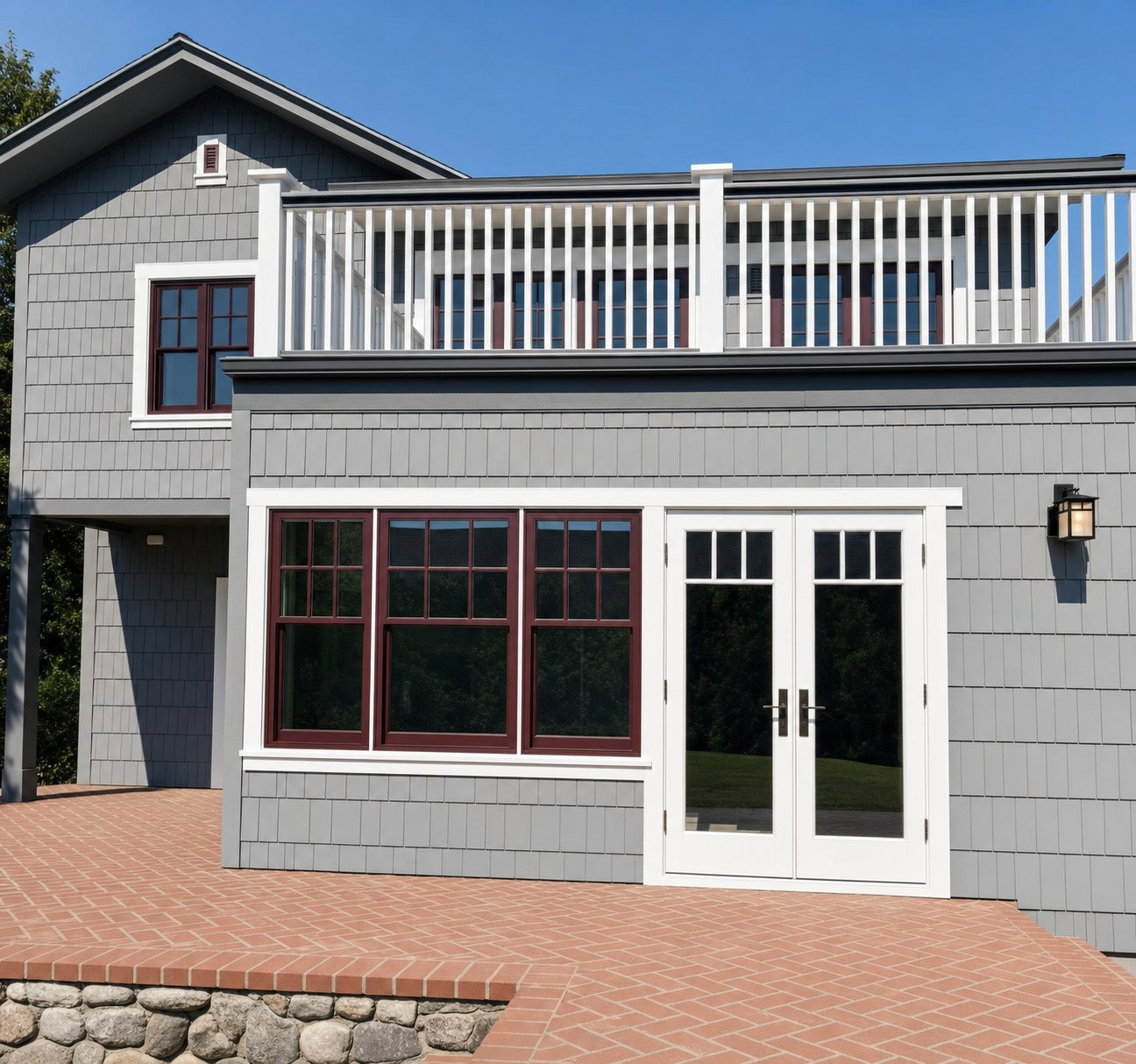 Gray shingle home with white trim and red sash windows