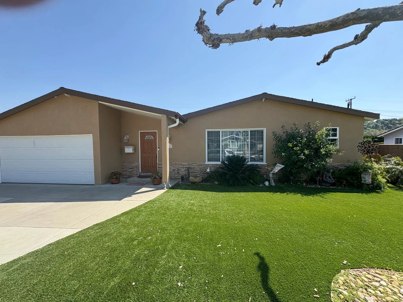 Tan stucco ranch home with stone veneer and clean trim